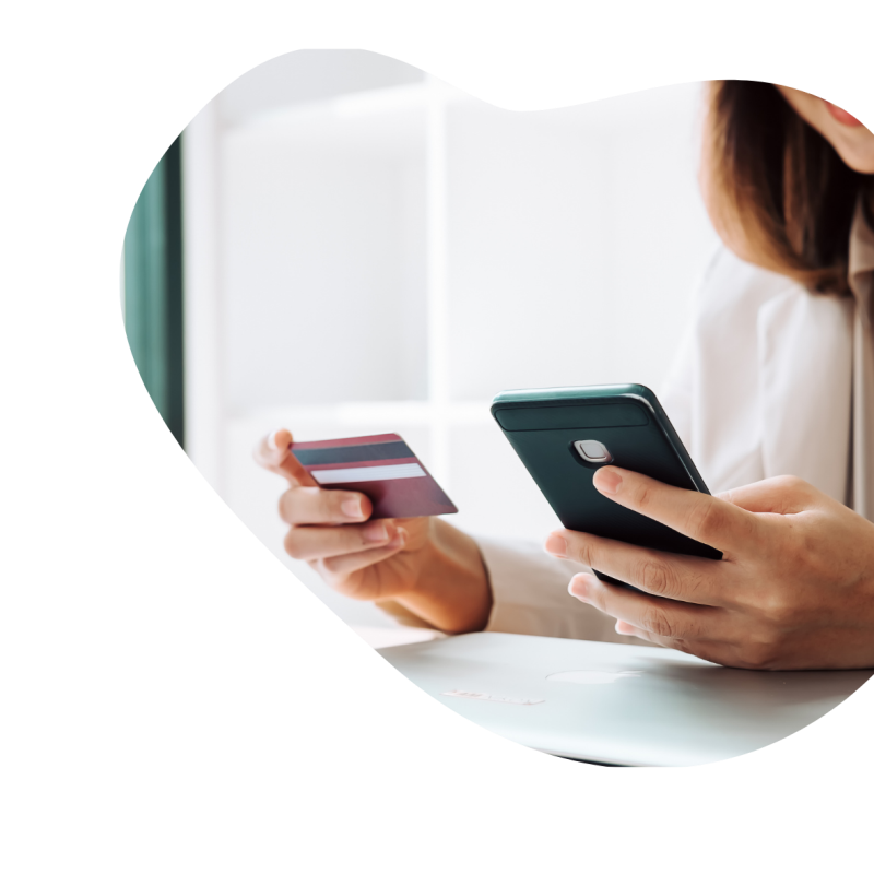 Eine Person hält in einer Hand ein Handy und in der anderen Hand eine EC-Karte