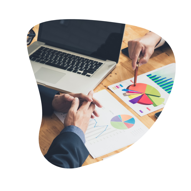 Zwei Personen sitzen an einem Tisch mit einem Laptop und Papier, dass ein Kreisdiagram abbildet