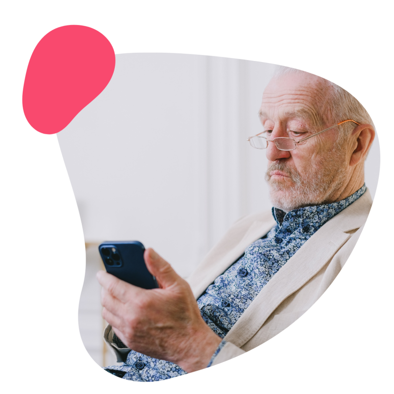 Ein Patient mit einer Brille hält ein Handy in der Hand