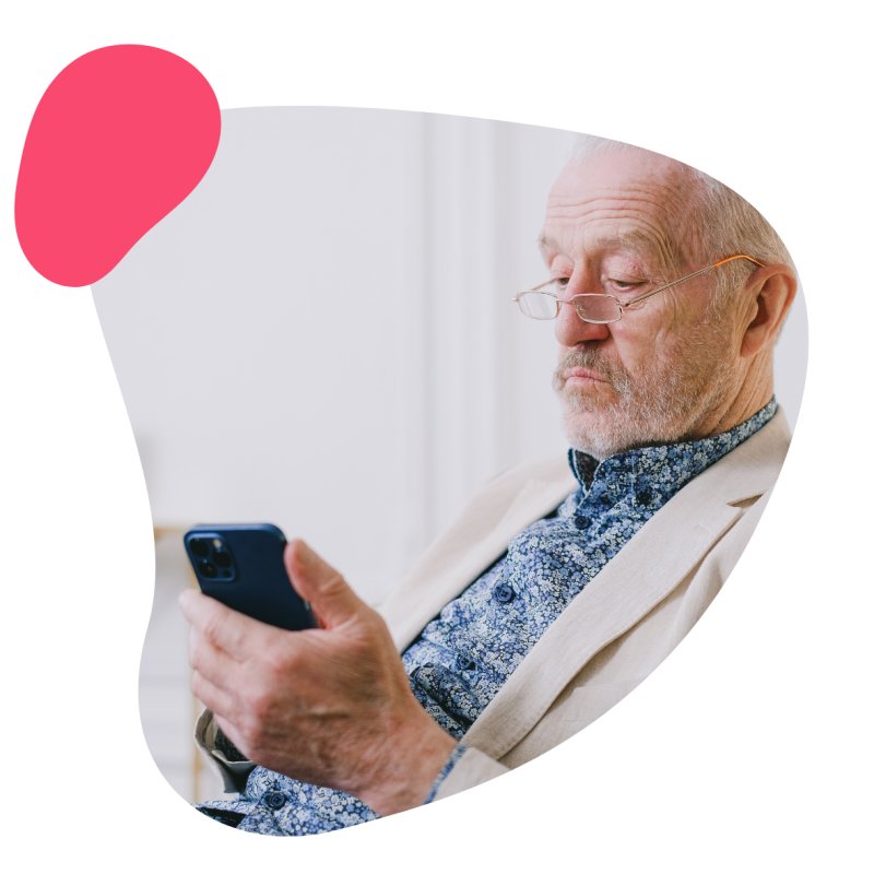 Ein Patient mit einer Brille hält ein Handy in der Hand