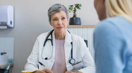 Frau in einem Arztkittel berät eine Patientin