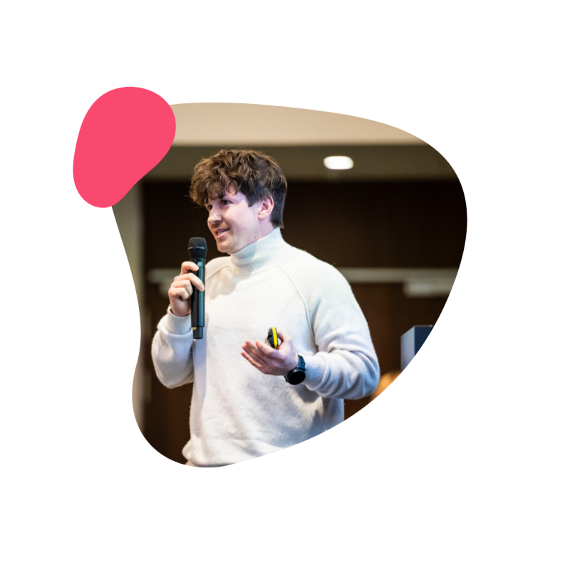 Mann in einem hellen Pullover und einem Mikrofon in der Hand