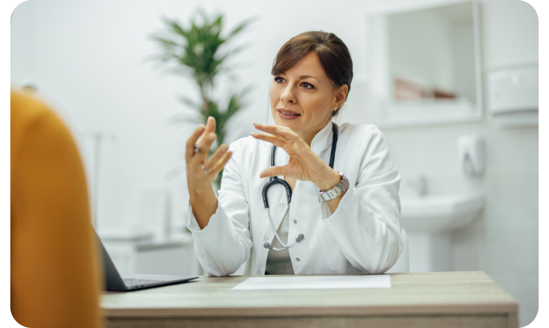 Ärztin in einem weißen Kittel berät einen Patienten